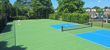 A tennis court with a net and two blue courts.